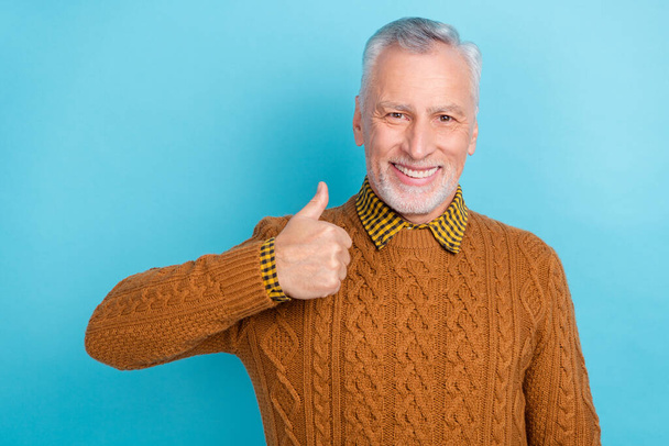 Photo of pretty confident man pensioner dressed brown pullover showing thumb up isolated blue color background - 写真・画像