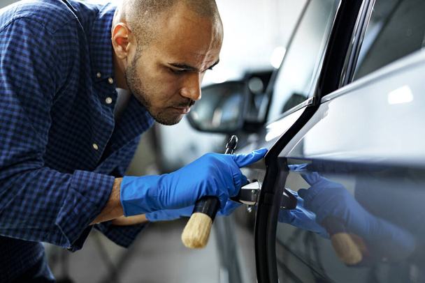 African American man car service worker applying nano coating on a car - Фото, зображення