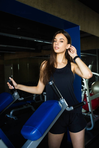 Young beautiful woman performs exercise in modern gym club - Foto, Imagem