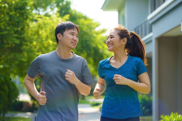 Asian couple are jogging in the neighborhood for daily health and well being, both physical and mental and simple antidote to daily stresses and to socialize safely - Foto, Imagem