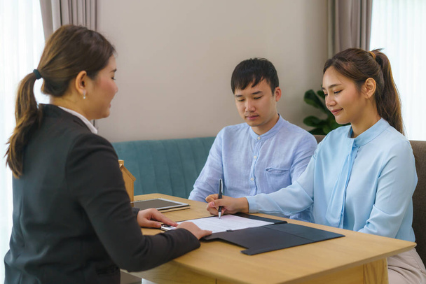 Agentes de bienes raíces de mujer asiática están teniendo clientes firman contratos para vender sus casas  - Foto, imagen
