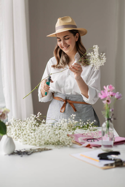 happy woman making bunch of flowers at home - Foto, immagini