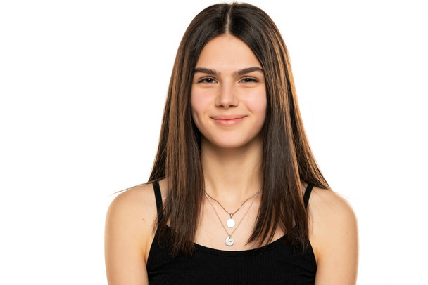 portrait of a beautiful smiling teenage girl with long straight hair and no makeup on a white background - Foto, afbeelding