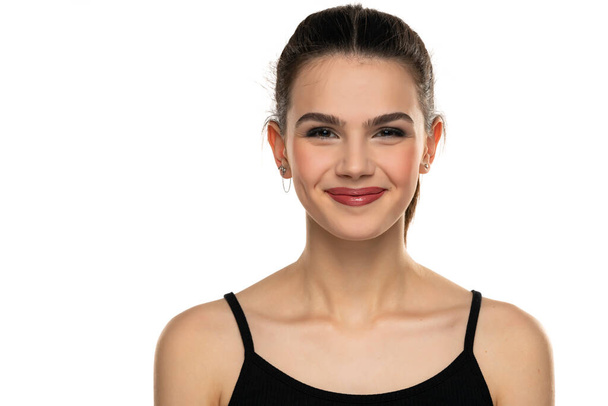 retrato de una adolescente sonriente con la boca cerrada sobre un fondo blanco - Foto, imagen