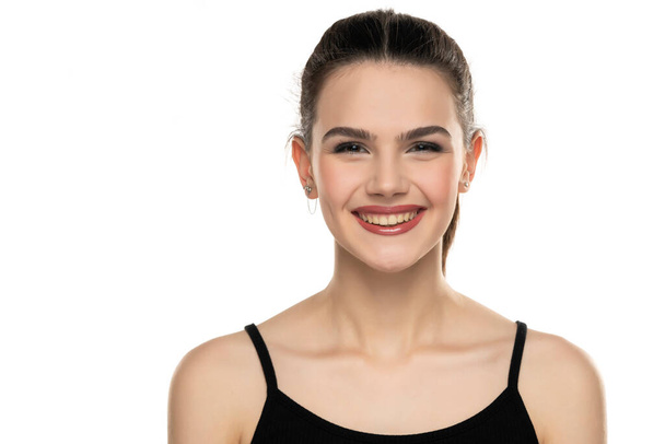 retrato de una adolescente sonriente con el pelo atado sobre un fondo blanco - Foto, imagen