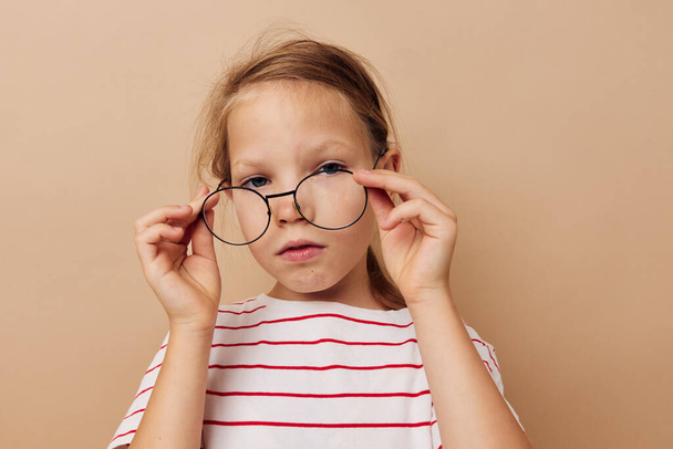 cute little girl round glasses posing beige background - Photo, image