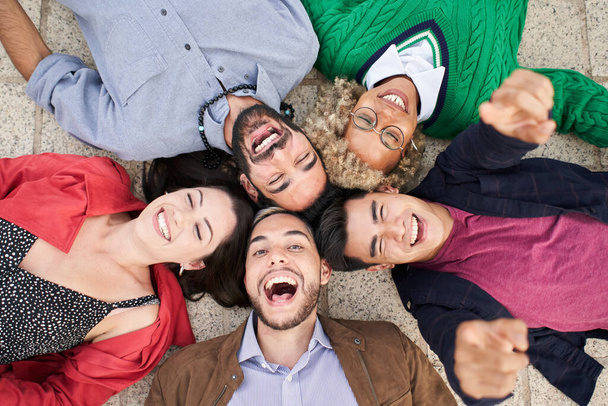 Selfie of a group of friends lying in a circle looking at the camera. - Foto, Imagem