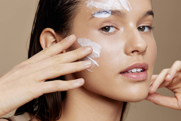 Frau Anwendung einer beruhigenden Gesichtsmaske kosmetische beige Hintergrund - Foto, Bild