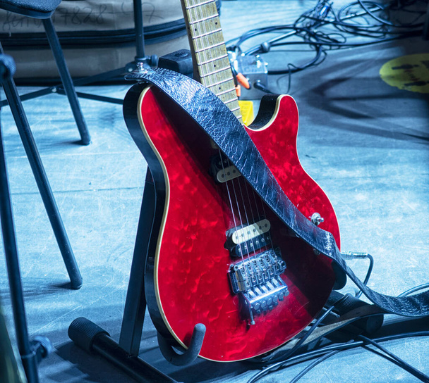 Elektromos gitárok a koncert előtt a színpadon a reflektorok fényében. - Fotó, kép