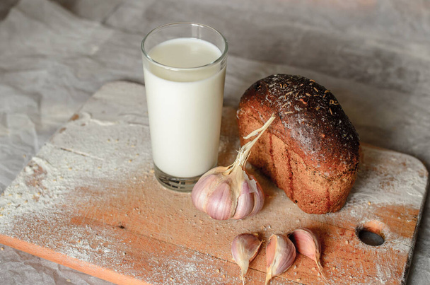 Still life of milk, bread and garlic. - Foto, imagen