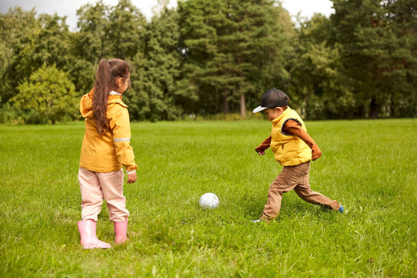 little children with ball playing soccer at park - Foto, Bild