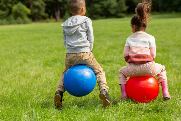 little children bouncing on hopper balls at park - Foto, Bild