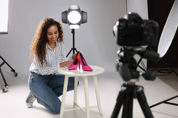 Professional photographer taking picture of stylish shoes in studio - Фото, изображение