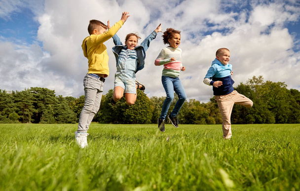 happy children jumping at park - Fotoğraf, Görsel