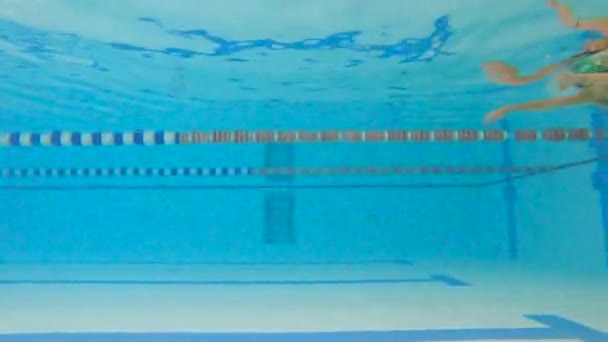 Mulher atleta nada debaixo d 'água na piscina. Movimento lento de uma nadadora na piscina durante o treino. - Filmagem, Vídeo