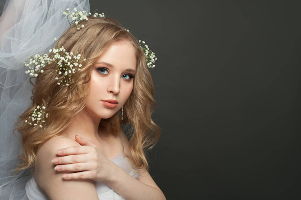 Blonde woman with fair curly hair and white flowers on her head - Photo, image