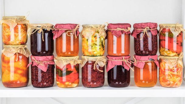 Fermented preserved vegetarian food concept. Variety of probiotics products and fermented foods on a white shelf. - Photo, Image