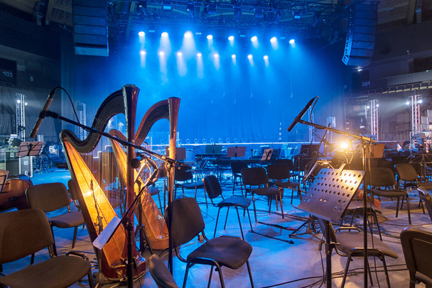 Muziekinstrumenten - muziekstandaards bevinden zich in de orkestzaal. In afwachting van de muzikanten voor de repetitie. - Foto, afbeelding