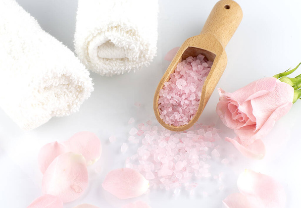 Rose petals with pink salt on wooden spoon and white towels on the white background - Valokuva, kuva