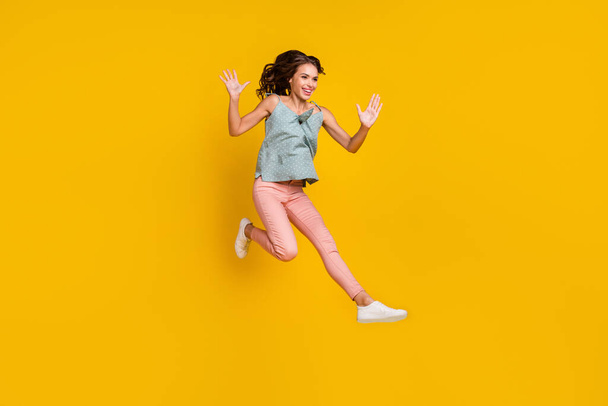 Full body photo of energetic positive woman jump up raise hands enjoy empty space isolated on yellow color background - Photo, Image
