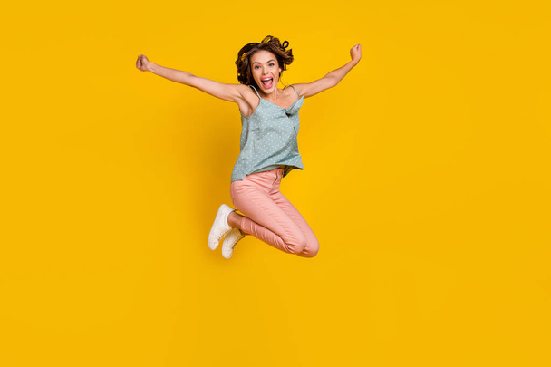 Full length photo of amazed excited happy woman jump up raise hands good mood isolated on yellow color background - Photo, image