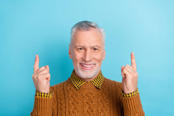 Photo of sweet cheerful man pensioner dressed brown pullover pointing up empty space isolated blue color background - Φωτογραφία, εικόνα