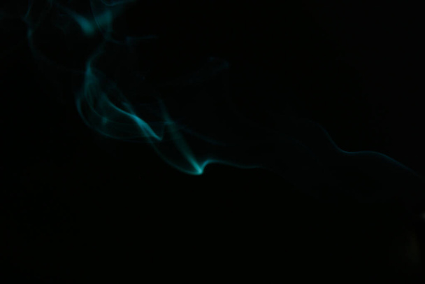 Green smoke pattern, beautiful puffs of smoke from cigarettes and hookah in the dark - 写真・画像