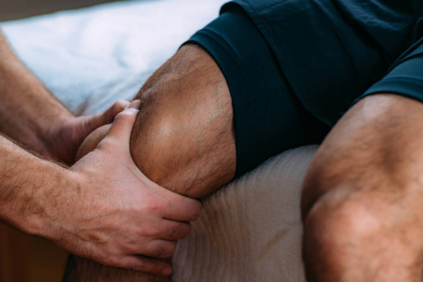 Knee sports massage physical therapy. Physiotherapist massaging injured knee. Sports injury treatment. - Fotografie, Obrázek