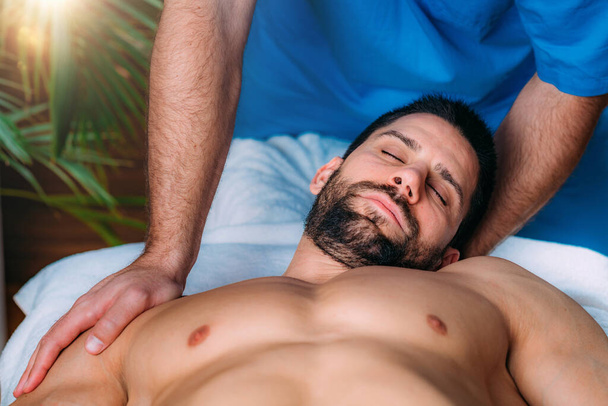 Physical therapy. Physiotherapist massaging injured neck. Sports injury treatment. - Photo, Image