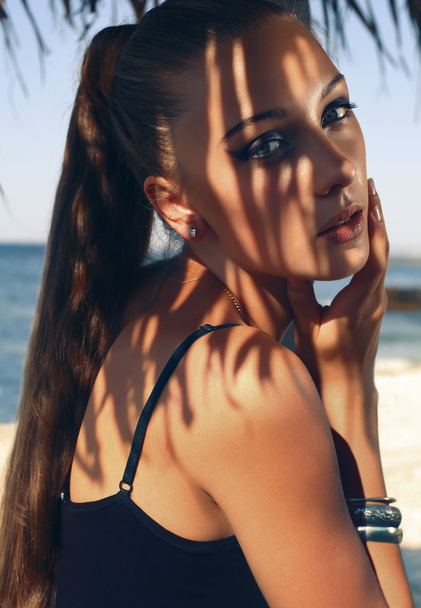 retrato de mujer joven y bonita con el pelo largo posando en la playa
 - Foto, Imagen