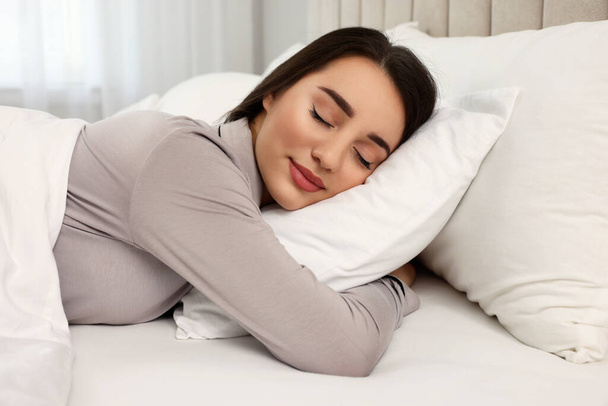 Beautiful young woman sleeping in bed at home - Фото, зображення