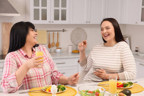 Happy overweight women having healthy meal together at table in kitchen - Fotoğraf, Görsel