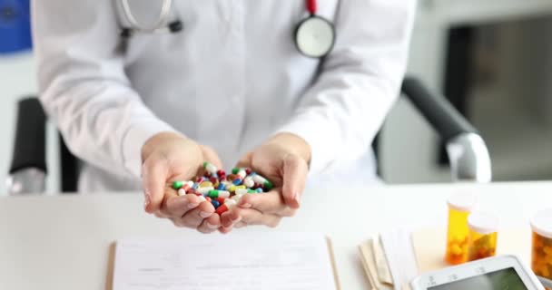 Dokter houdt handvol multi-gekleurde medische pillen in handen closeup - Video