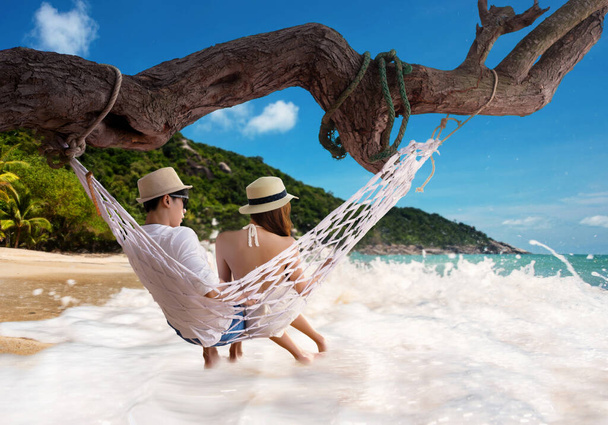 couple lover in motion of romantic sweet moment together sitting on the hammock of the sea beach, fun around in summertime vacation holidays or long weekend - Foto, immagini