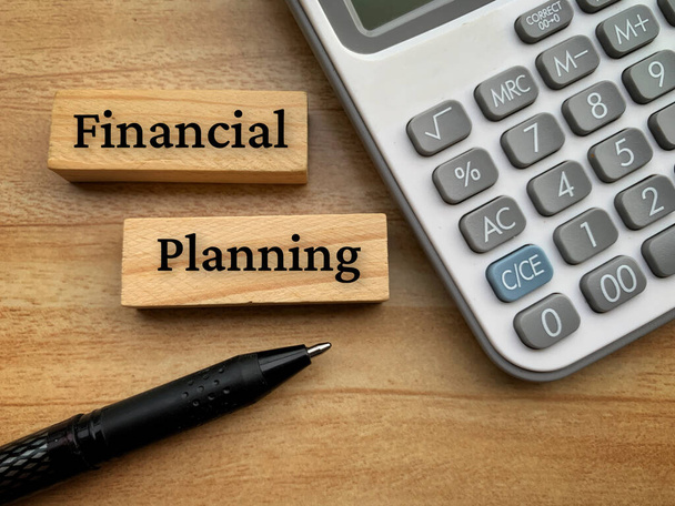 Texto de planificación financiera sobre bloques de madera con calculadora y fondo de lápiz. - Foto, Imagen