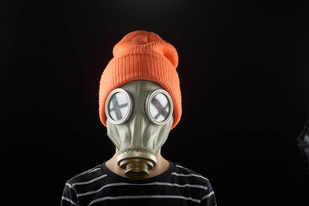 Portrait of a boy in a gas mask on a dark background - Fotoğraf, Görsel