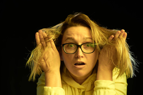 Adult woman in glasses with bad hair, on a dark background - Фото, зображення