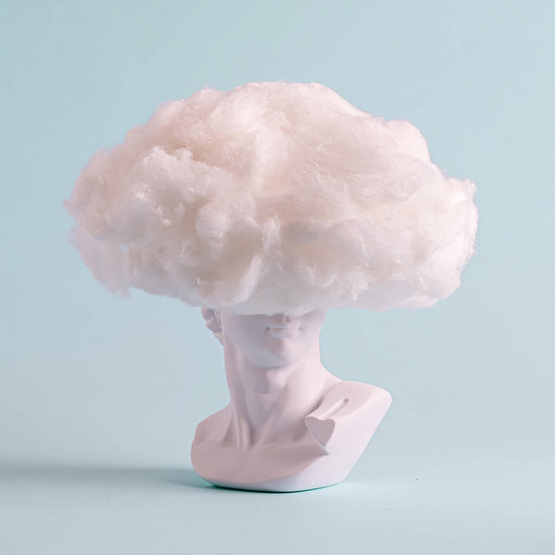 Natura morta divertente se un busto greco bianco con cappello lanoso, acconciatura o testa che copre la nuvola su uno sfondo blu pallido - Foto, immagini