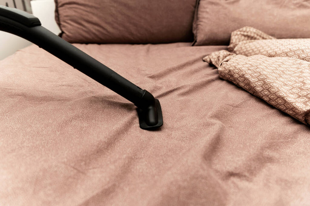 Vacuum the bed. Home cleaning concept. . Upholstered furniture. Cleaning conceptHouse, apartments, hotels. bed cleaning. - Valokuva, kuva