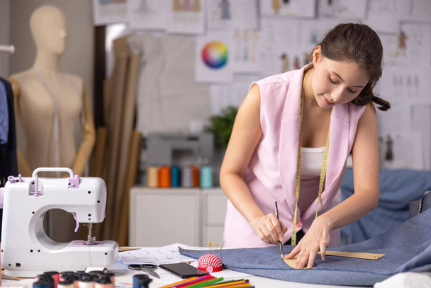 A munkahelyén egy ázsiai szabó módosítja egy próbabábun lévő ruhadarab tervét.. - Fotó, kép