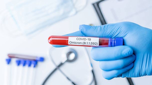 Omicron mutation coronavirus variant. Lékařský lékař drží zkumavku v nemocniční laboratoři. Pandemická prevence. Klinický výzkum - Fotografie, Obrázek