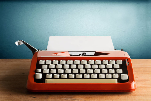 A typewriter whith a sheet of paper on a wooden desk - Fotoğraf, Görsel