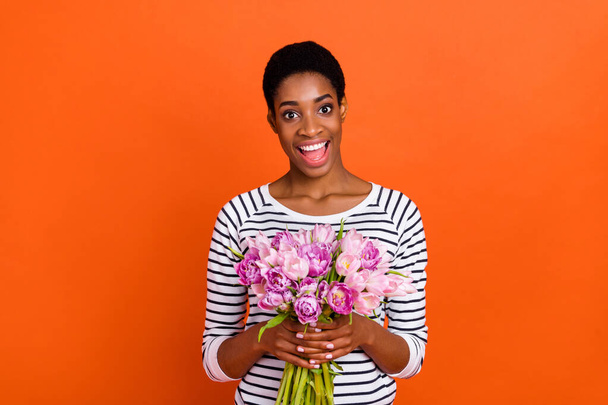Photo of shiny excited butch lady dressed sweater getting pink bouquet isolated orange color background - Fotó, kép