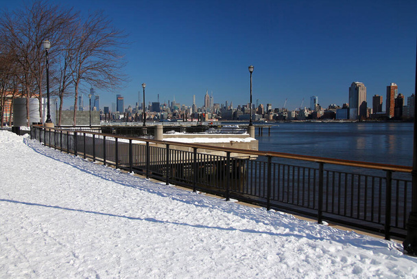 Midtown Manhattan és az Empire State Building a hó a Hudson River Walkaway Jersey City - Fotó, kép