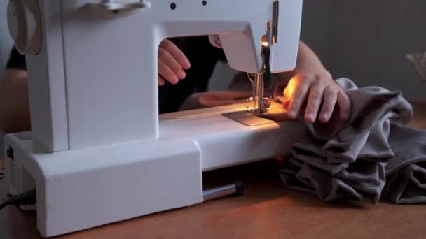 Close-up de um jovem mulheres mãos costura com uma máquina de costura - Filmagem, Vídeo