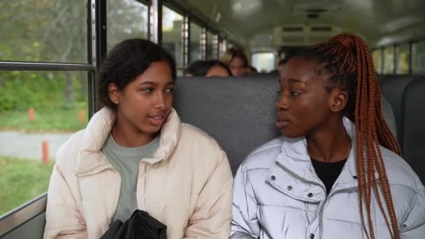 Vriendelijke multiraciale schoolmeisjes paardrijden schoolbus - Video