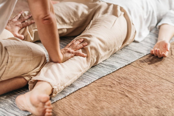 Masaje tailandés de acupresión Tratamiento del dolor de rodilla. Cliente femenino disfrutando de técnicas tradicionales de acupresión de rodilla de masaje tailandés. - Foto, Imagen