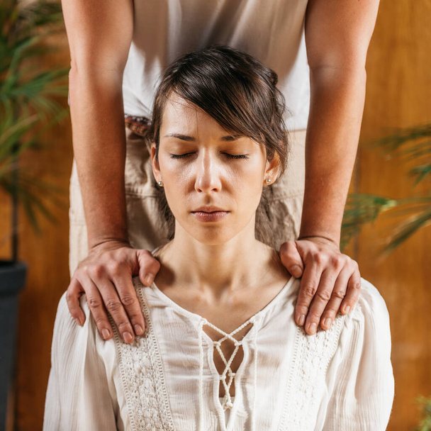 Thai Body Relaxing Massage. Masseurs hands holding female client shoulders, lowering stress and relieving muscular tension - 写真・画像