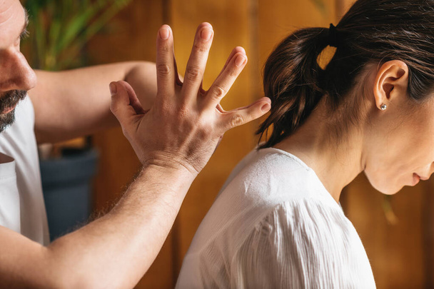 Tajski masaż - uśmierzenie bólu pleców. Masażysta przy użyciu tajskiej techniki masażu z rękami, aby rozluźnić napięcie szyi i ramion. - Zdjęcie, obraz