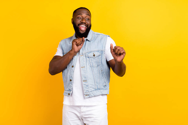 Portrait of attractive funky cheerful guy dancing celebrating having fun isolated over bright yellow color background - Fotó, kép